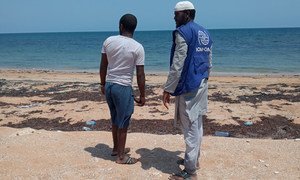 A staff member of the IOM in Djibouti talks to a migrant who arrived in the African country by boat.