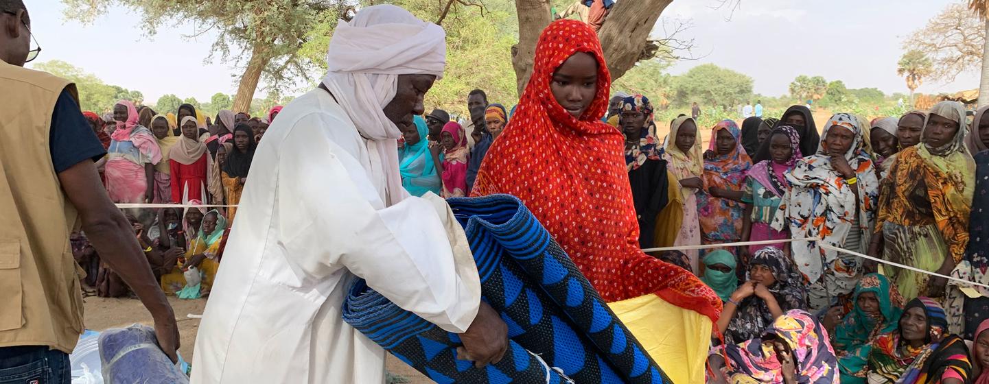 Des réfugiés soudanais récupèrent des articles de secours distribués par l'UNICEF et ses partenaires à Kounfroun, au Tchad.