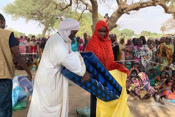 苏丹难民在乍得库恩弗鲁恩（Kounfroun）领取由儿基会及其合作伙伴分发的救济物品。