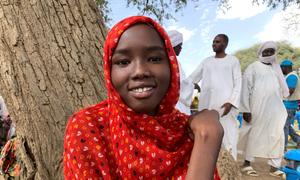 A young girl who fled Sudan with her family waits for a distribution of relief aid in Chad.