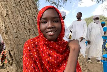 Une jeune fille qui a fui le Soudan avec sa famille attend une distribution d'aide humanitaire au Tchad.