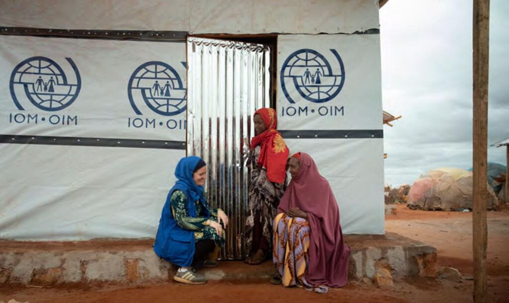 A worker for the UN's International Organization for Migration provides support to a woman in Sudan.