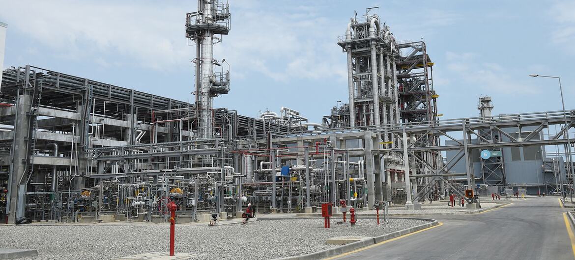 An exterior view of the SOCAR Polymer polypropylene plant in Sumgayit, Azerbaijan, showing industrial towers and piping against a blue sky.