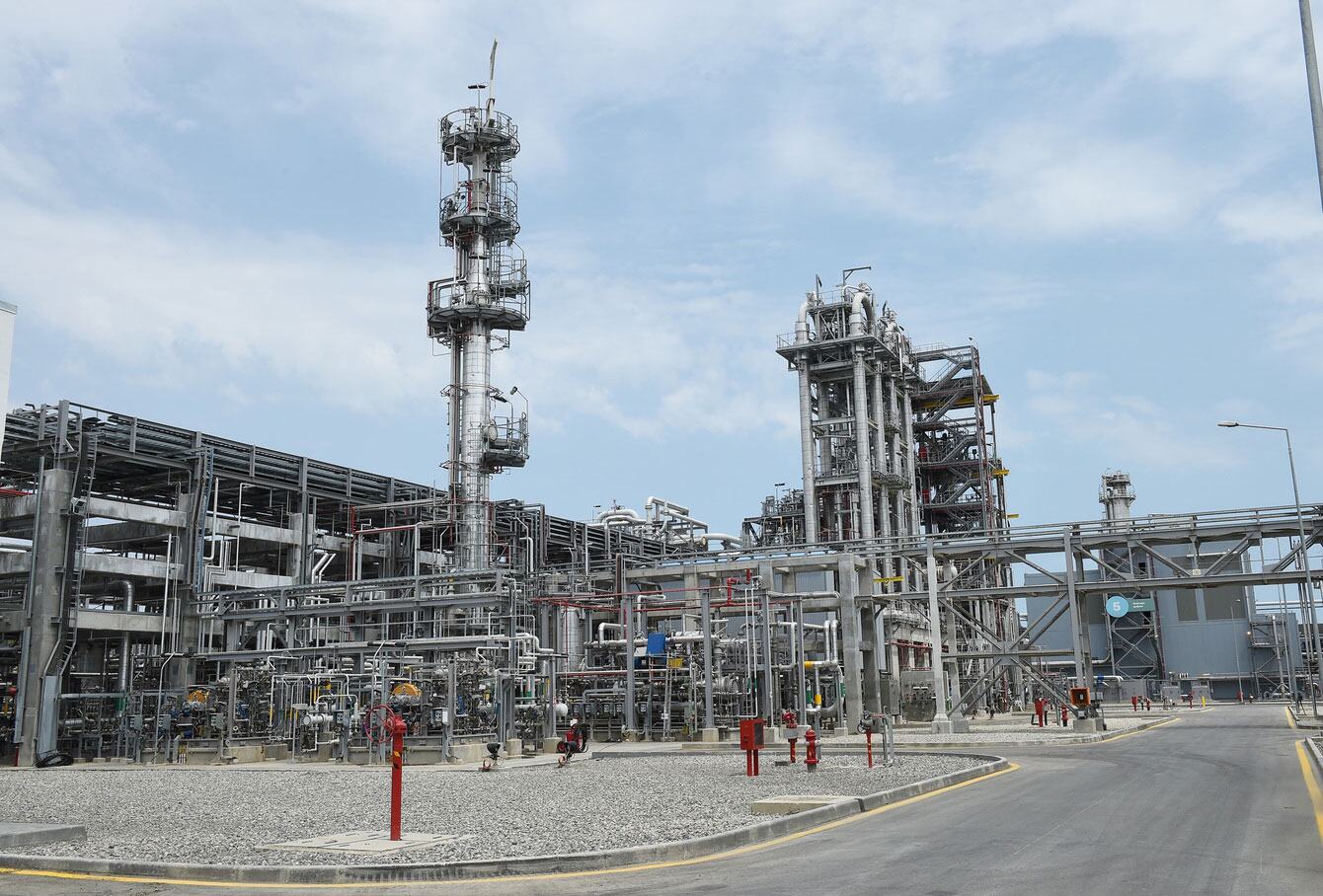 منظر خارجي لمصنع SOCAR Polymer للبولي بروبيلين في سومقاييت، أذربيجان، يُظهر الأبراج الصناعية والأنابيب أمام سماء زرقاء.