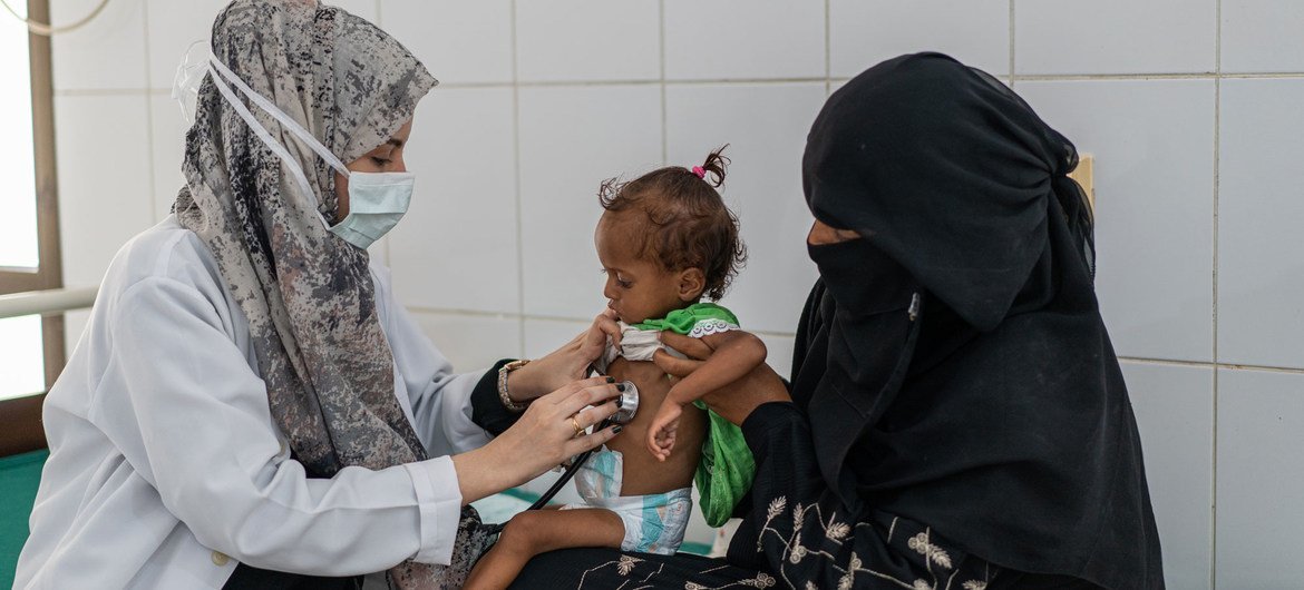 أم في اليمن تأخذ ابنتها البالغة من العمر 18 شهرا لتلقي العلاج من سوء التغذية.