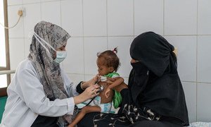 Uma mãe no Iêmen leva a filha de 1,5 ano para ser tratada por desnutrição 