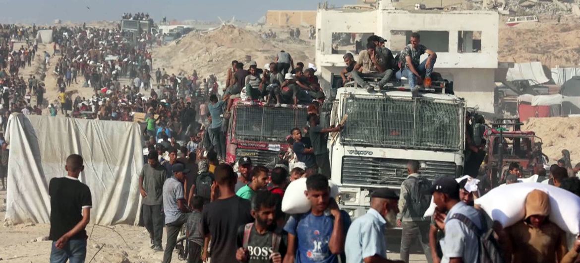 Thousands of people seek aid delivered across the Israeli Zikim border point in northern Gaza.