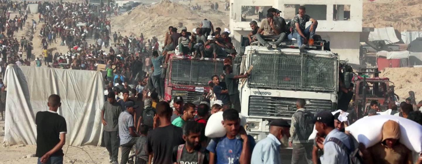 Thousands of people seek aid delivered across the Israeli Zikim border point in northern Gaza.