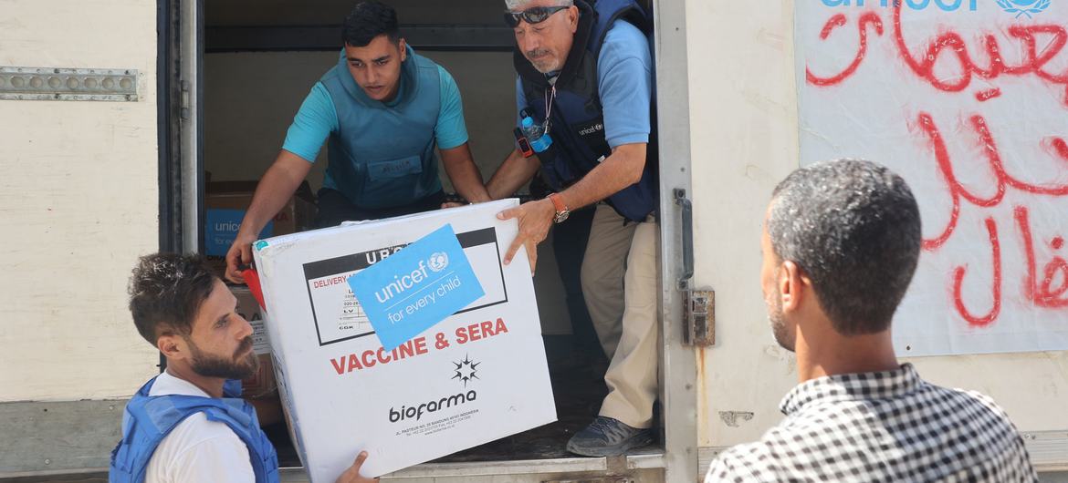 موظفو اليونيسف يقومون بتفريغ شحنة من لقاحات شلل الأطفال في مستودع المنظمة في دير البلح في قطاع غزة.
