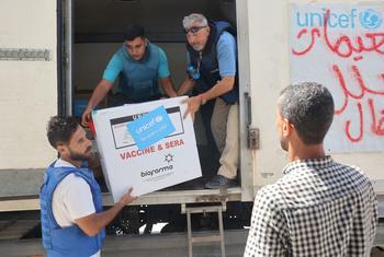 موظفو اليونيسف يقومون بتفريغ شحنة من لقاحات شلل الأطفال في مستودع المنظمة في دير البلح في قطاع غزة.