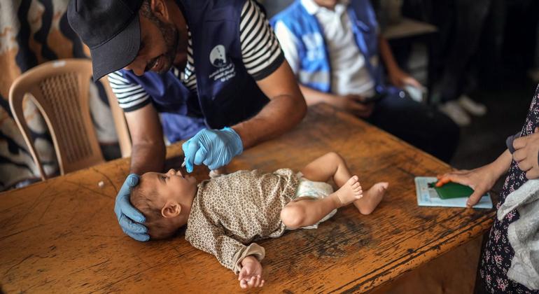 A health worker administers the polio vaccine to a baby in Gaza.