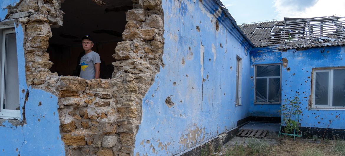 Un garçon se tient à l'intérieur des vestiges de son école à Novohryhorivka, en Ukraine. 