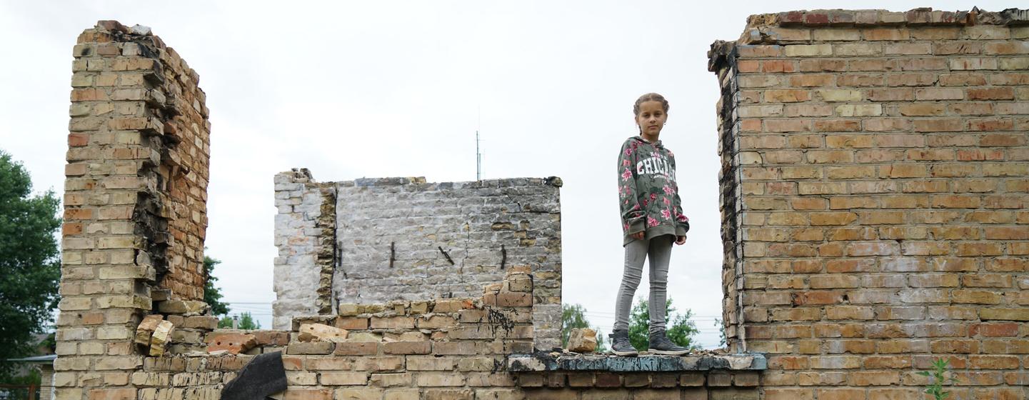 فتاة تقف بين أنقاض مدرستها في ضواحي العاصمة الأوكرانية كييف.