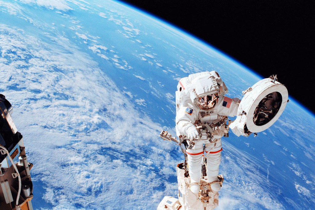 Um astronauta  trabalhando na Estação Espacial Internacional enquanto ela orbita a Terra.