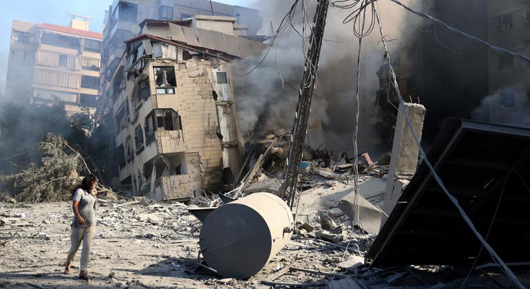 Una mujer camina frente a un edificio destruido por los bombardeos israelíes en el sur de Beirut.