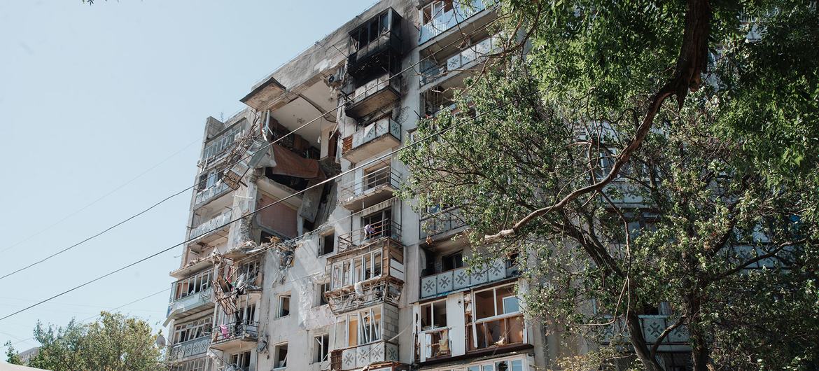 Un edificio de apartamentos de varias plantas en Ucrania muestra graves daños por incendio y misiles tras un ataque, con balcones carbonizados y ventanas rotas.