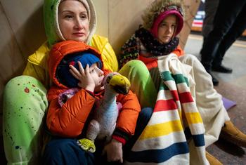 A mother and her two children take refuge from bombardments in a Kyiv metro station in January 2024.