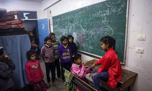 أطفال فلسطينيون يلعبون معا في فصل دراسي بمدرسة تحولت إلى مركز إيواء في مدينة رفح، غزة.