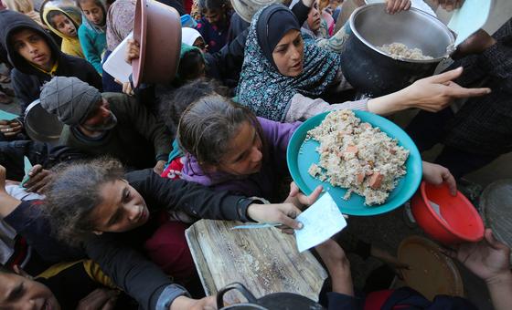 La gente de Gaza intenta desesperadamente conseguir comida en un punto de distribución de UNRWA.