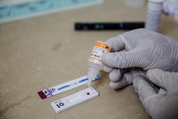 Un technicien de laboratoire portant des gants effectue un test de dépistage du VIH dans un établissement médical de Peshawar, au Pakistan.