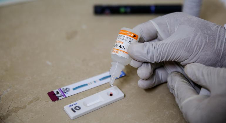 Un técnico de laboratorio, con guantes, realiza una prueba de detección del VIH en un centro médico de Peshawar, Pakistán.