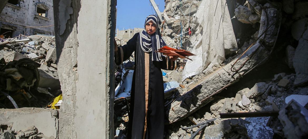 A young woman walks through the ruins of homes in Gaza.