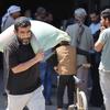 رجل في قطاع غزة يحمل العلف الحيواني الذي قدمته منظمة الأغذية والزراعة.