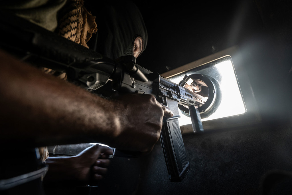A Haitian police officer keeps watch while patrolling the streets of Port-au-Prince in an armoured vehcile.