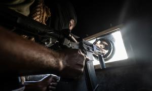 A Haitian police officer keeps watch while patrolling the streets of Port-au-Prince in an armoured vehcile.