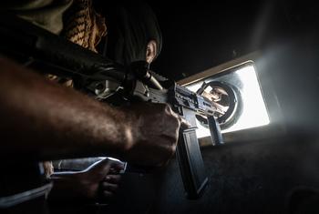 A Haitian police officer keeps watch while patrolling the streets of Port-au-Prince in an armoured vehcile.