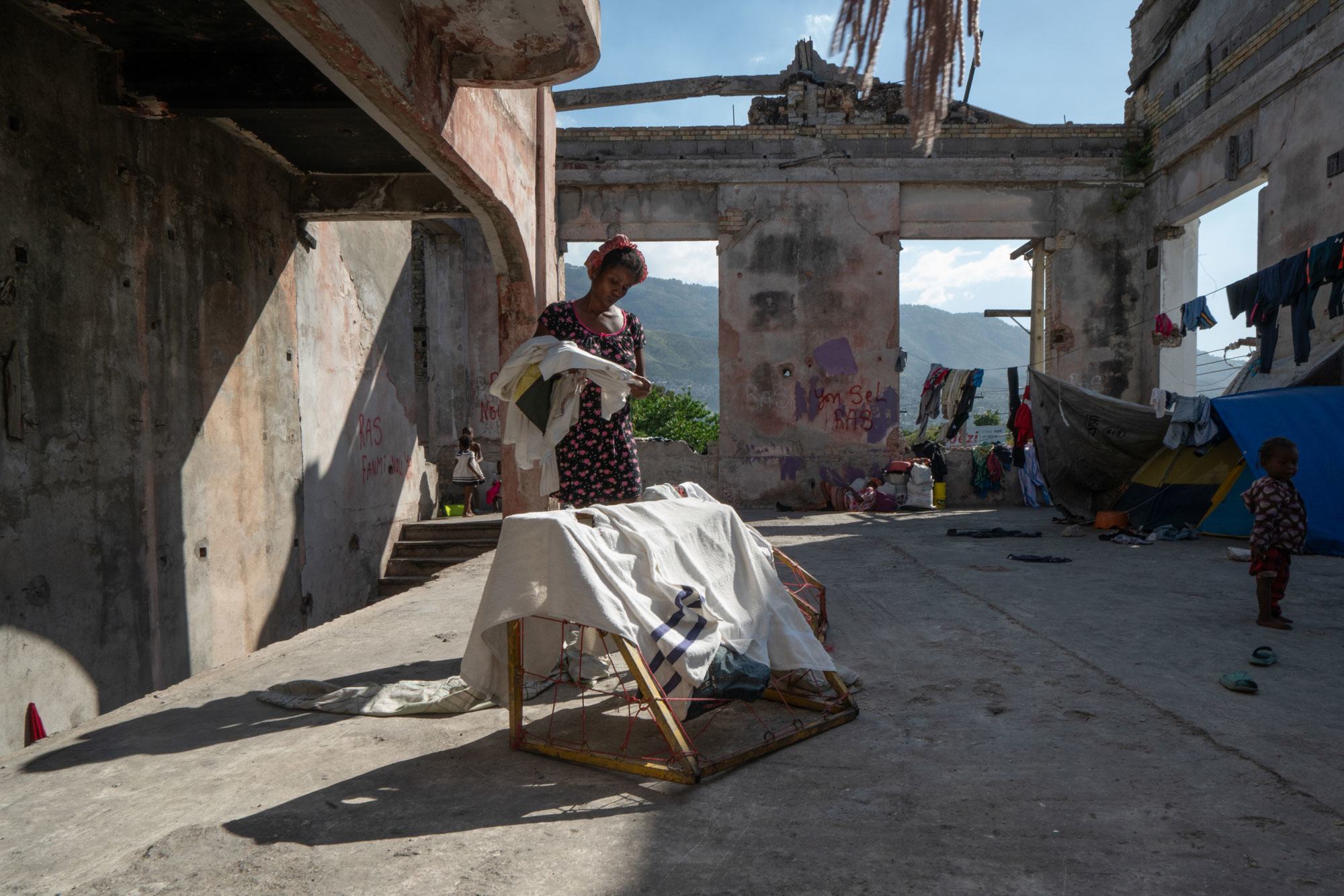 Женщина, потерявшая кров в результате бандитских разборок, теперь живет в разрушенном здании театра в центре Порт-о-Пренса.