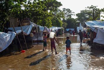 People walk through a flooded township in Myanmar following the early arrival of monsoon rains.