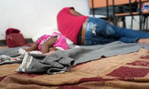 Una niña y un adulto duermen en un centro para personas desplazadas en Haití.