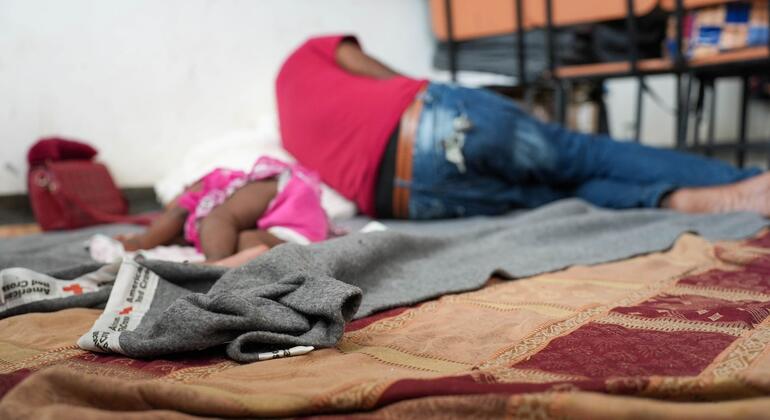 Una niña y un adulto duermen en un centro para personas desplazadas en Haití.