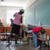 Une femme nettoie une salle de classe dans le département du Centre d’Haïti où elle est hébergée avec sa famille.