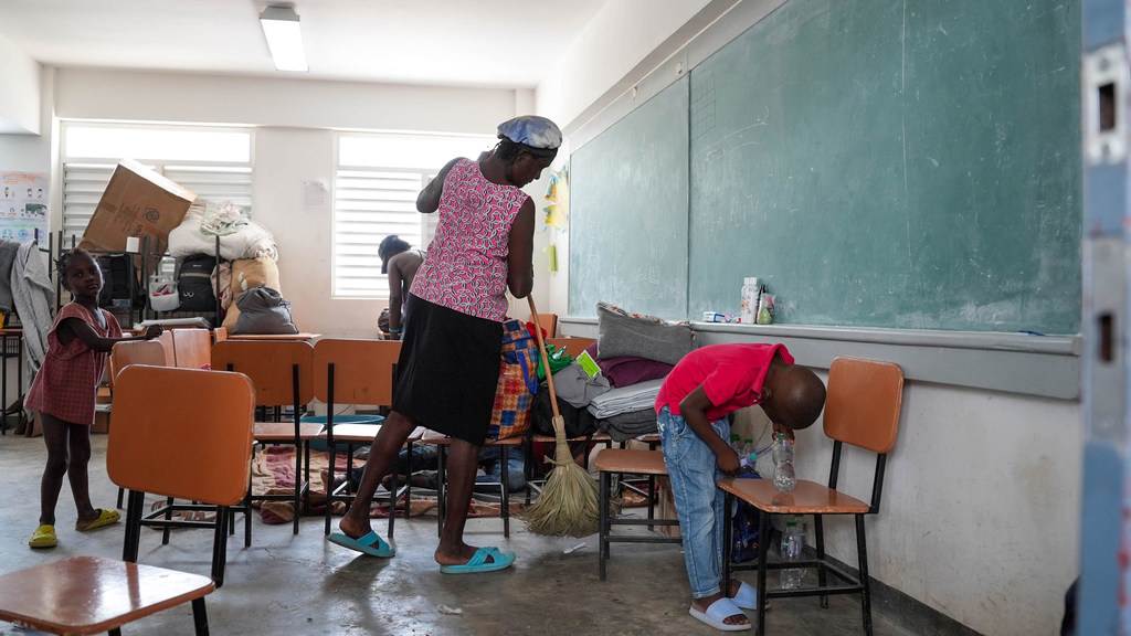 Une femme nettoie une salle de classe dans le département du Centre d’Haïti où elle est hébergée avec sa famille.