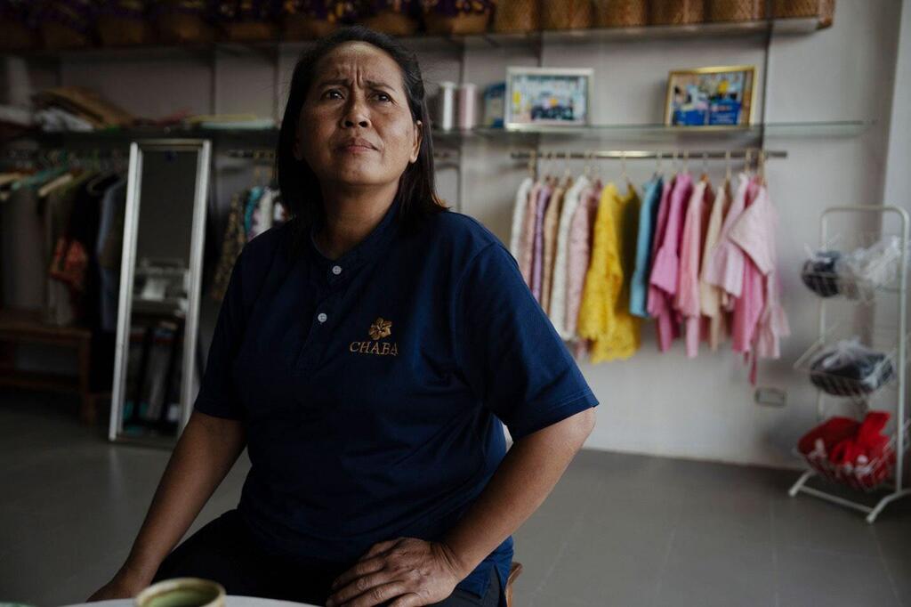 Mariyam Tadein sits in the clothes shop where she works in Phatthalung in southern Thailand.