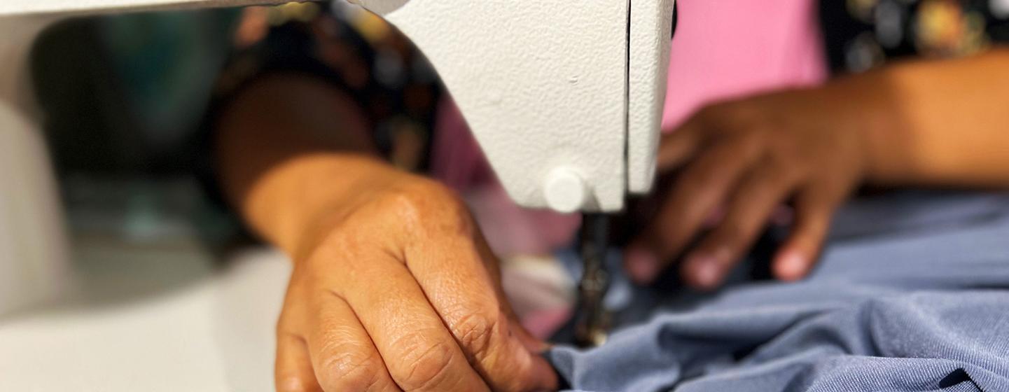 A cooperative member sews a garment at Olango Sindaw Ko Kauyagan Producer cooperative in Piagapo, village.