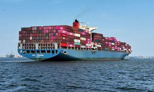 Un gran buque de contenedores llamado MOL CHARISMA navega sobre el mar abierto, cargado de coloridos contenedores de envío.