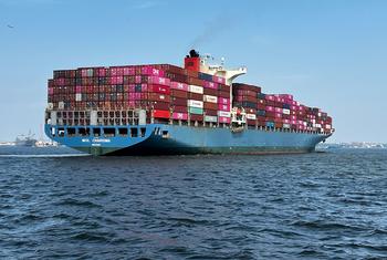 Un gran buque de contenedores llamado MOL CHARISMA navega sobre el mar abierto, cargado de coloridos contenedores de envío.