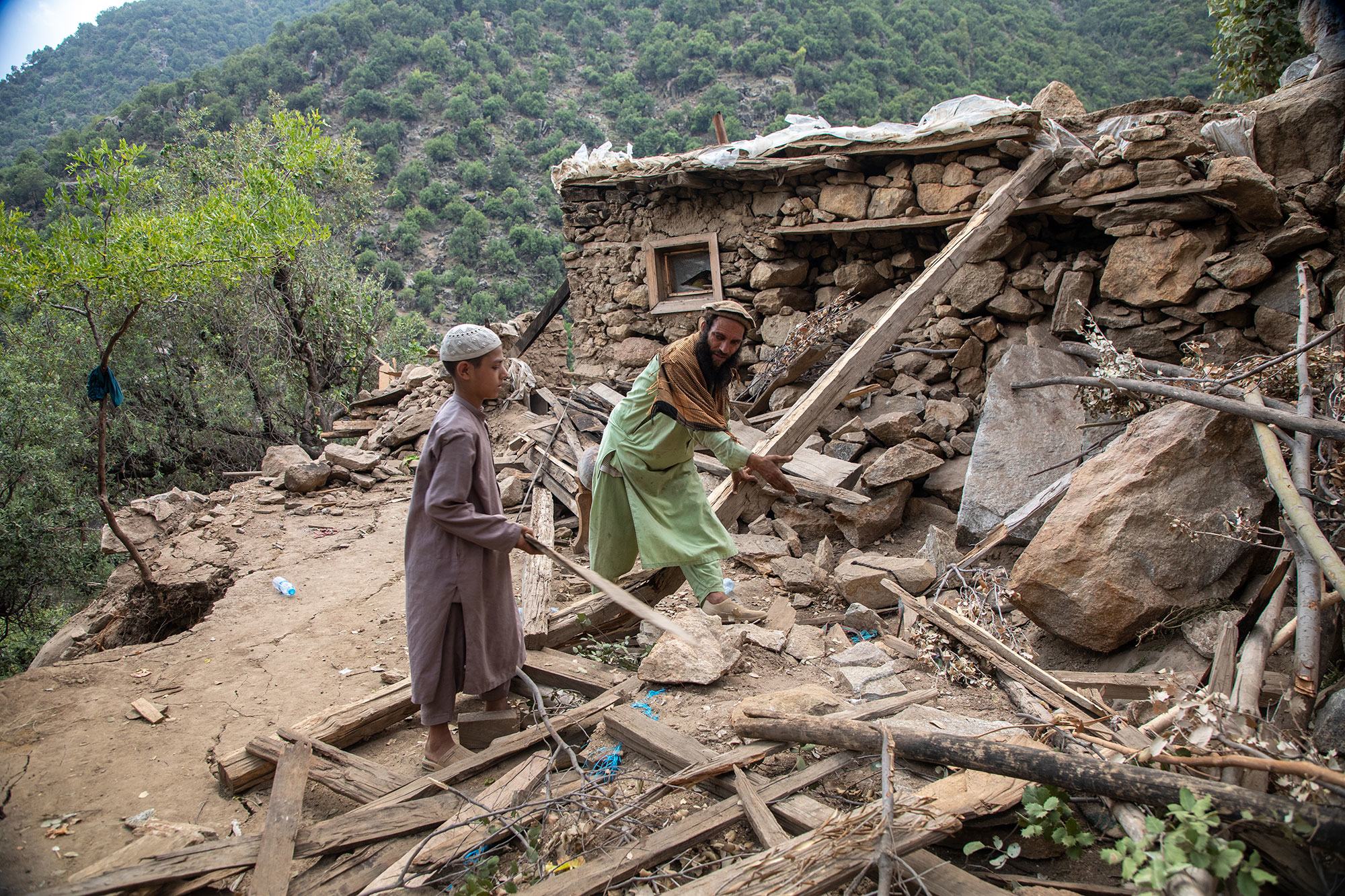 Un père et son fils déblayent les décombres de leur maison après le séisme survenu dans la province de Kounar, en Afghanistan.
