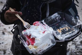 Un niño en Mongolia disfruta de un pastel azucarado de una tienda cerca de su escuela, destacando el problema de los hábitos alimenticios poco saludables entre los niños debido al fácil acceso a la comida chatarra.
