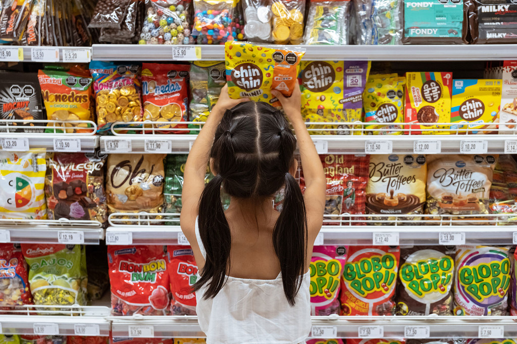 A young girl chooses sweets at a supermarket in Lima, Peru.