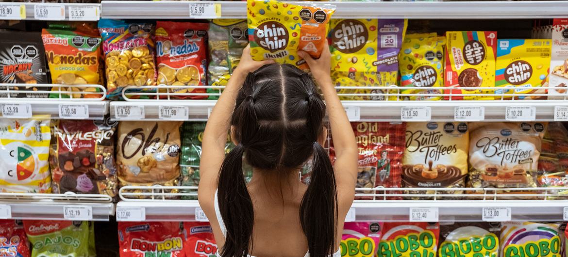 A young girl chooses sweets at a supermarket in Lima, Peru.