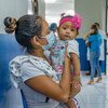 Una madre lleva a su bebé al hospital para una visita médica rutinaria en El Salvador. 