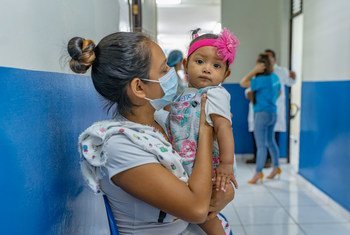 Una madre lleva a su bebé al hospital para una visita médica rutinaria en El Salvador. 