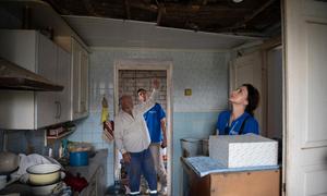 Human rights officers examine a kitchen where a rocket landed in Posad-Pokrovske in the Kherson region of Ukraine.