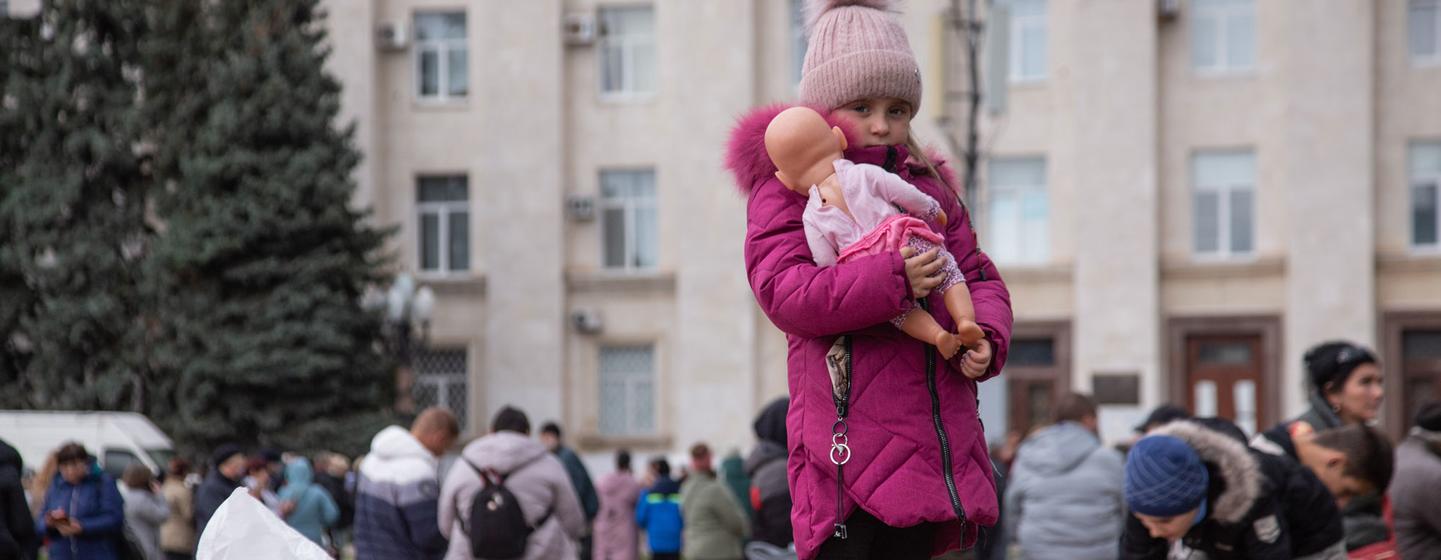 Une fille tient sa poupée sur la place centrale de Kherson, en Ukraine.