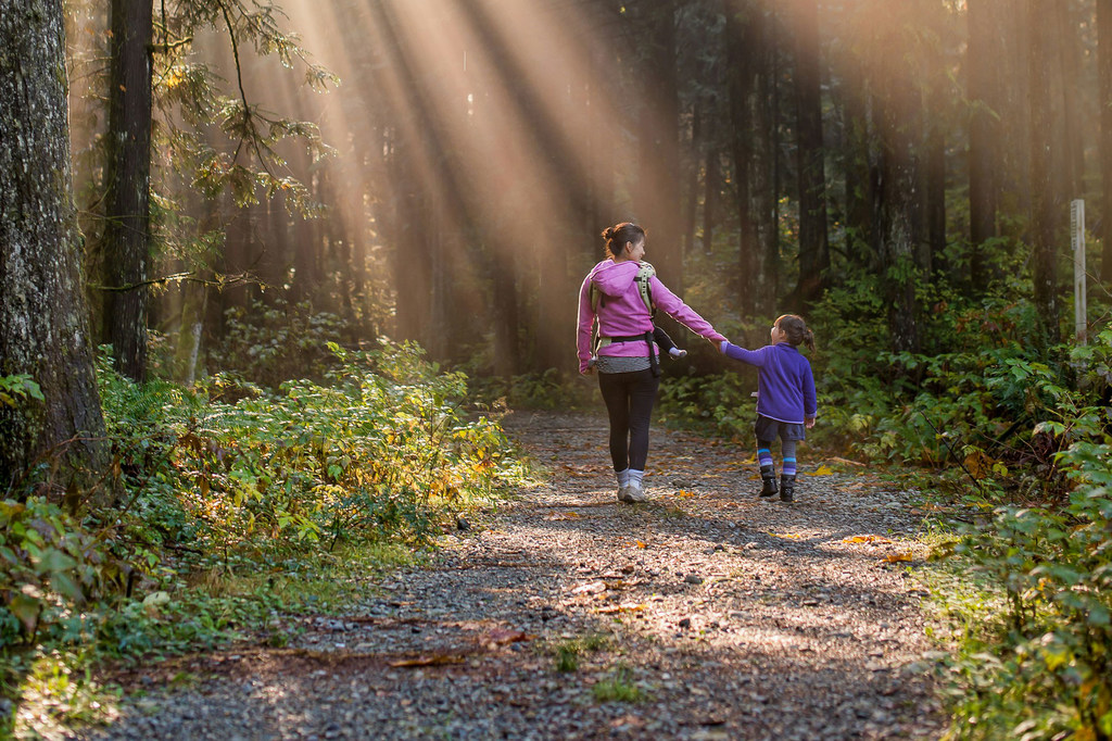 A woman and child walk through a forest in British Columbia Ridge, Canada.