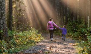 Una mujer y un niño caminan por un bosque en British Columbia Ridge, Canadá.